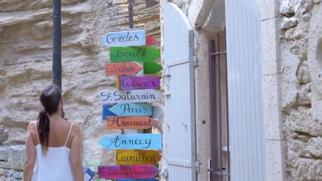 woman walking around old small village in france that says where to go, paris, gordes