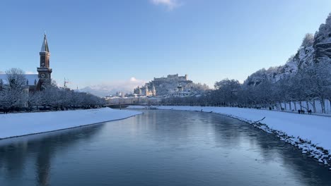 establishing shot of river salzach in snowy white salzburg city, austria