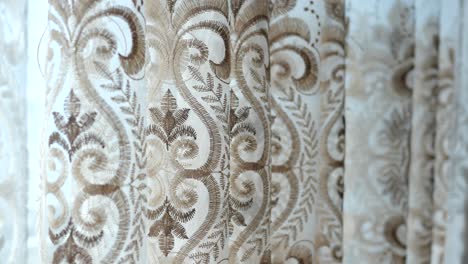 close-up of white sheer curtains with brown embroidery