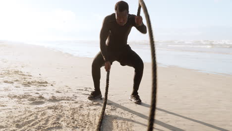 black man, fitness and battle rope on beach