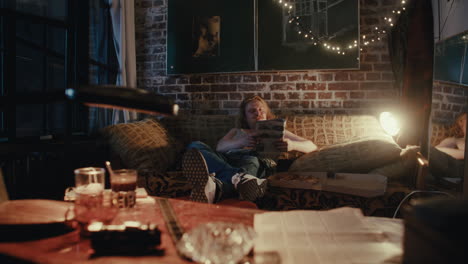man relaxing at home with pizza and magazine