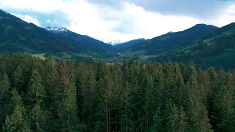 Aerial-view-across-woodland-forest-trees-and-scenic-mountainous-landscape-in-High-Tauern-national-park,-Salzburg-state