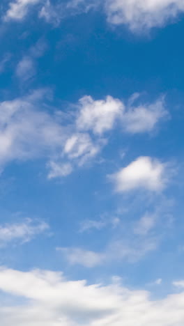 beautiful little white clouds fly in the sky and disperse in the wind. low angle view. timelapse. vertical video