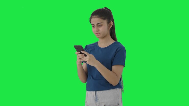 una adolescente india enojada enviando un mensaje a alguien pantalla verde