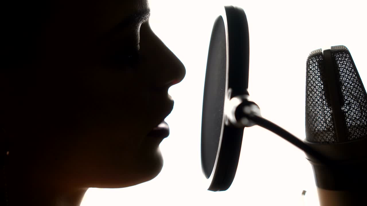 Beautiful young singer who recorded a song in a professional recording studio.