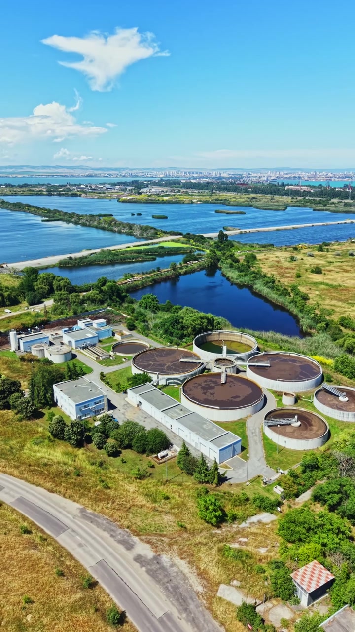 Water treatment plant near a river with green landscape and blue sky in the background during the daytime