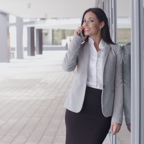 hermosa mujer sonriente en el teléfono fuera de la oficina