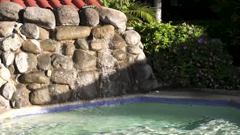 cascada de roca de cemento artificial y piscina en el resort en san josé costa rica, tiro medio portátil