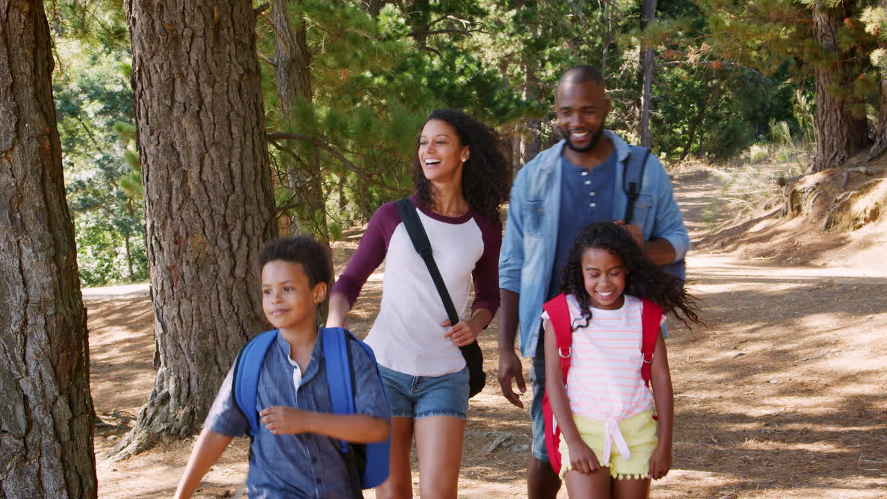 Family On Hiking Adventure Walking Along Path Through Woods