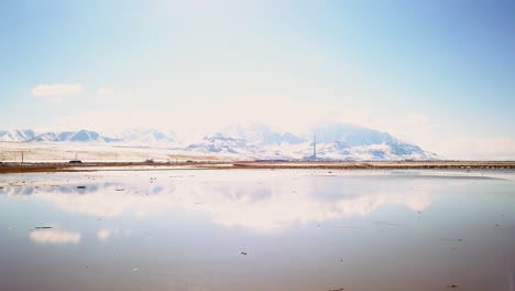 Strahlender-Morgensonnenschein,-Spiegelung-Der-Berglandschaft-Und-Der-Autobahn-Mit-Autos-Und-Lastwagen-Auf-Salt-Lake,-SLC,-Utah,-Filmische-Aufwärtsbewegung