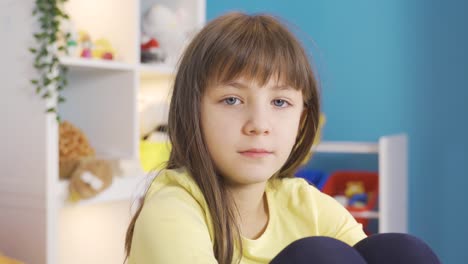 cute little girl with blond hair and blue eyes looking at camera.
