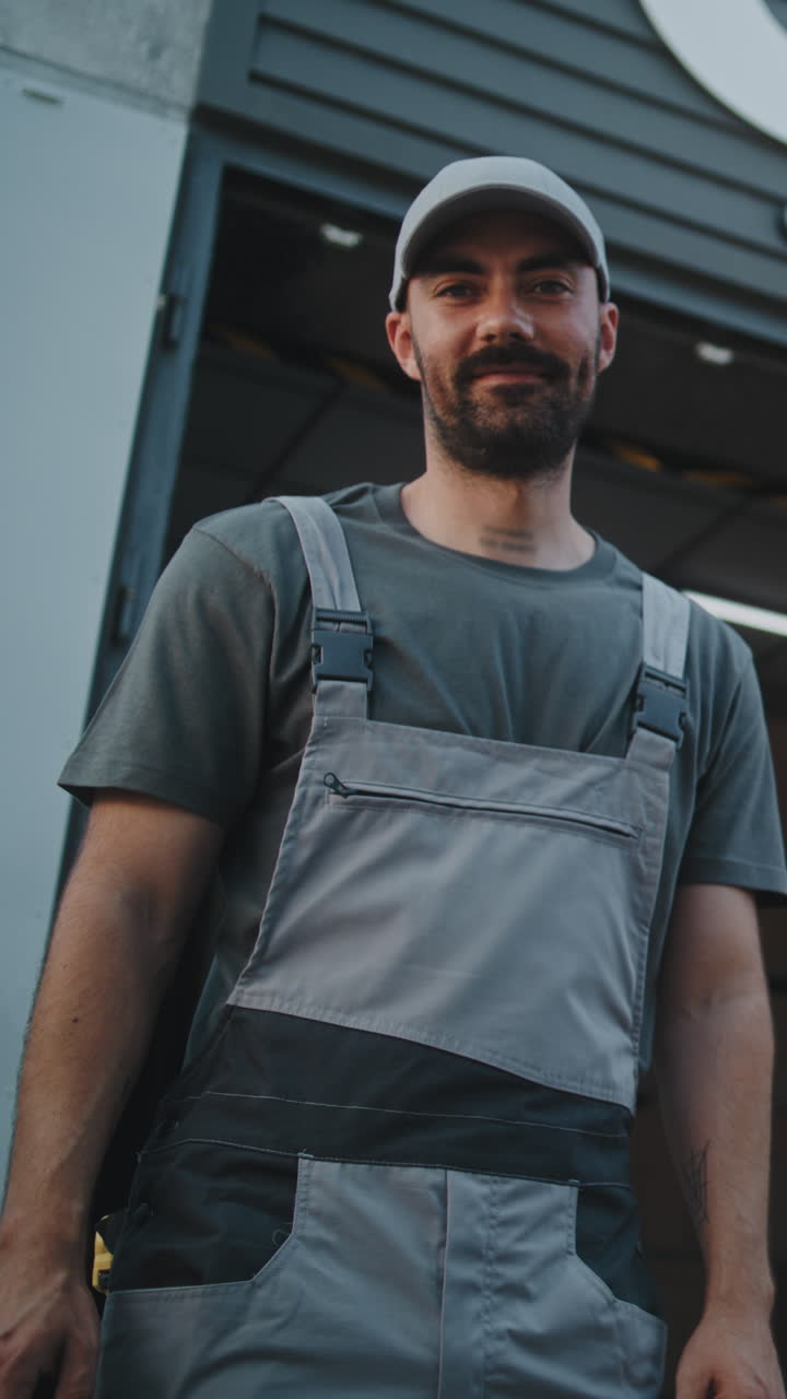 Man in work uniform, potentially a delivery person, in an industrial setting