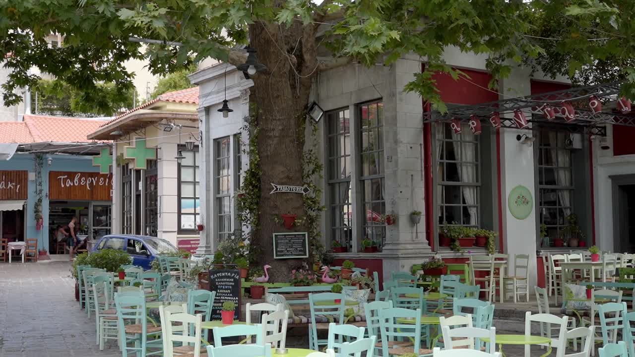 A traditional taverna (cafe) in the streets of Agiasos village with empty chairs, Gimbal shot