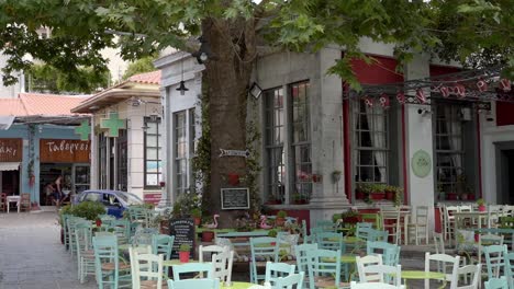 a traditional taverna (cafe) in the streets of agiasos village with empty chairs, gimbal shot
