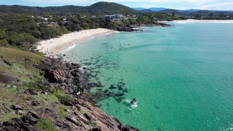 waves splashing on rocky norries headland in cabarita beach, tweed shire, bogangar, northern rivers, new south wales, australia aerial pull back shot