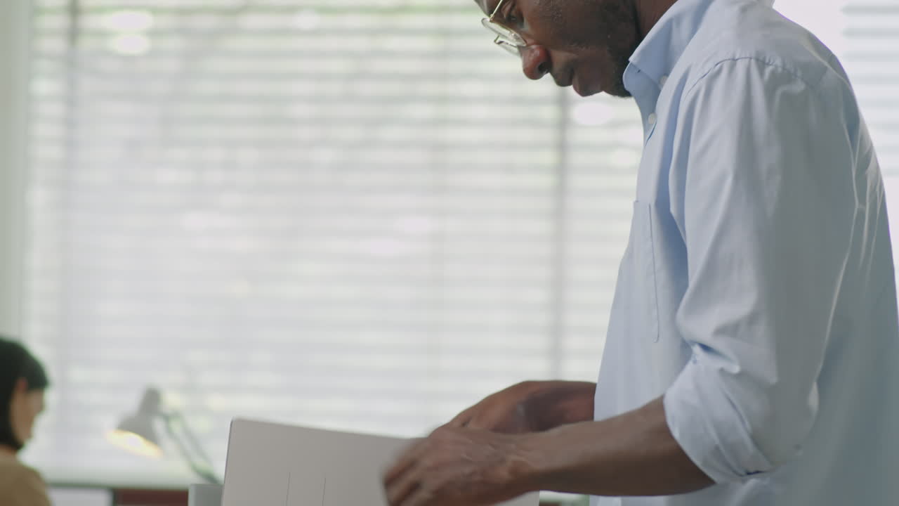 Fired Black Businessman Packing Office Stuff into Box