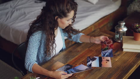 woman looking at photos on a wooden table in her home