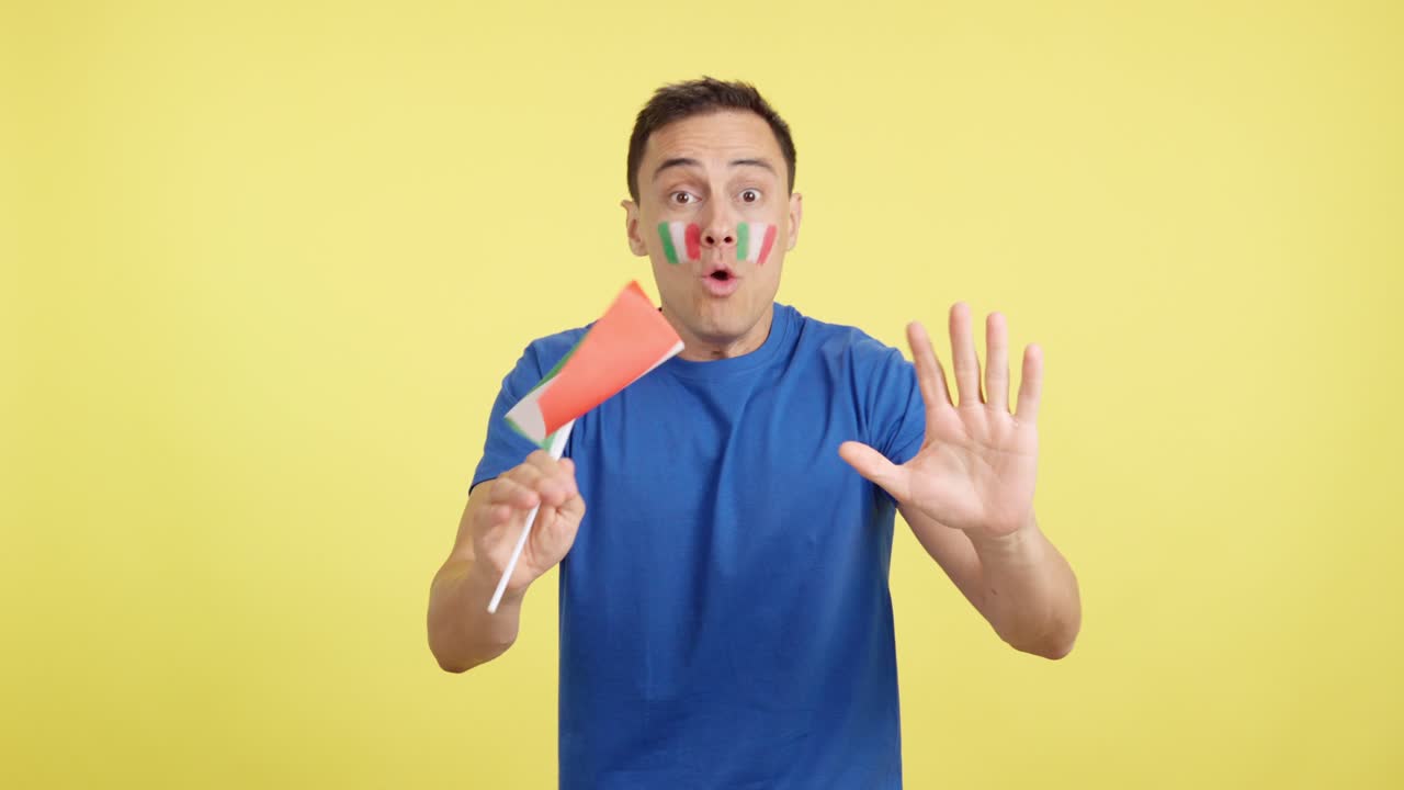 Passionate italian supporter screaming and waving a national flag