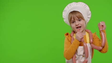 Teen-child-girl-dressed-as-cook-chef-in-apron-dancing-with-sausages,-fooling-around-on-chroma-key