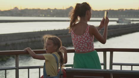 a turkish mother and daughter enjoying the view at the stern of the boat