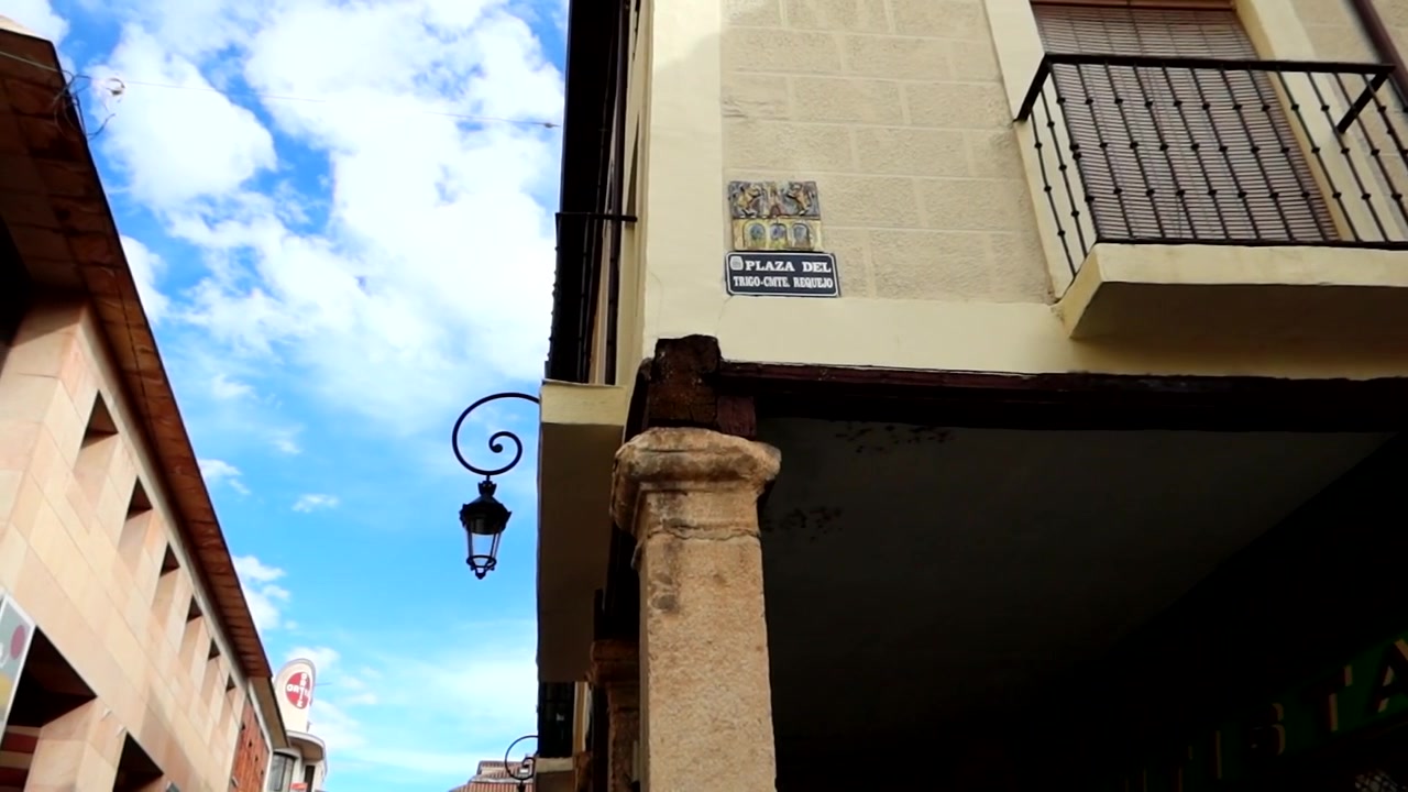 Inquadratura dal basso di muri in stucco castigliano e balcone in una giornata di sole. Panoramica a sinistra.