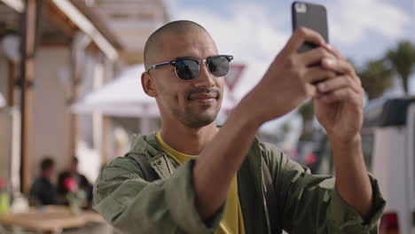 portrait-of-attractive-young-man-wearing-sunglasses-taking-photo-using-phone