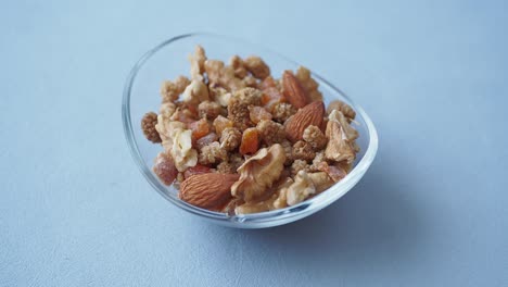 a bowl of trail mix with walnuts, almonds, and dried fruit