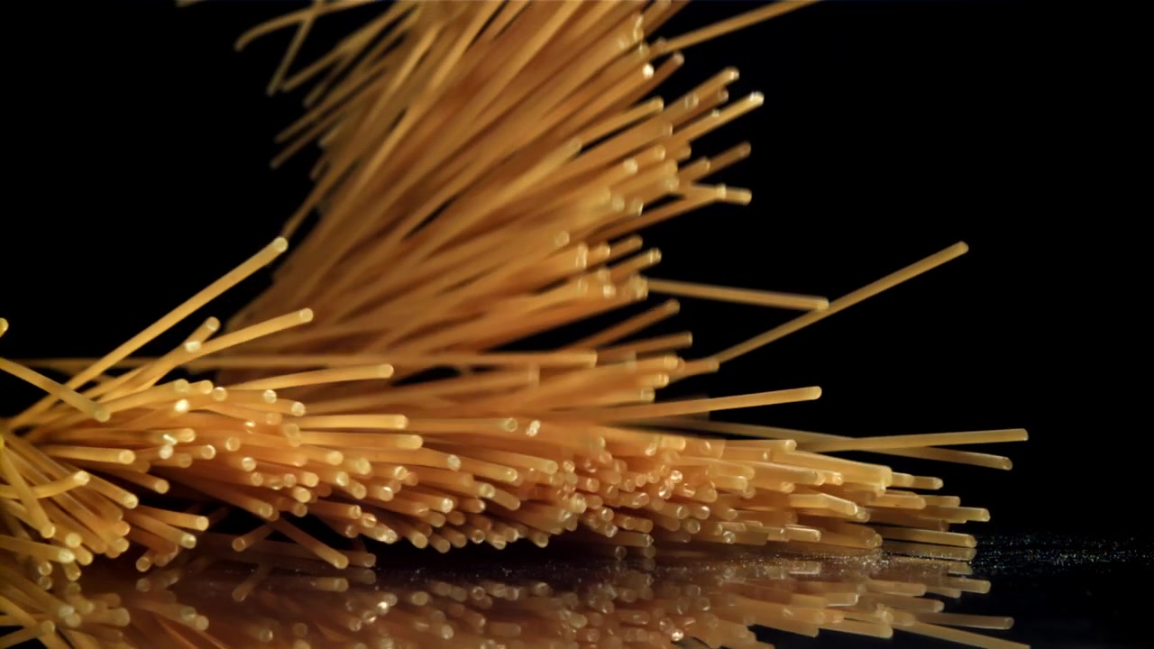 Spageti Kering Jatuh dalam Gerak Lambat di Latar Belakang Hitam