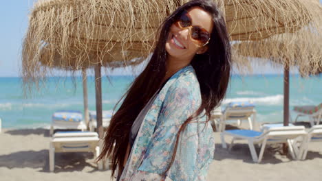 Cheerful-Young-Lady-at-the-Beach-Looking-at-Camera