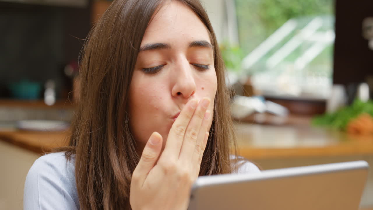 A joyful woman waving during a video call being