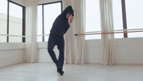 young male dancer practicing modern dance during studio rehearsal