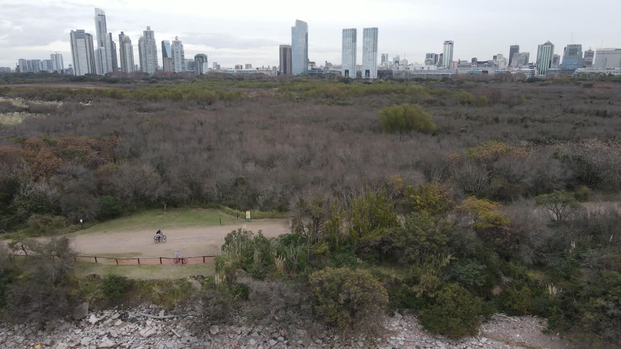 gente en bicicleta en el camino frente al horizonte de la ciudad en buenos aires en un día nublado
