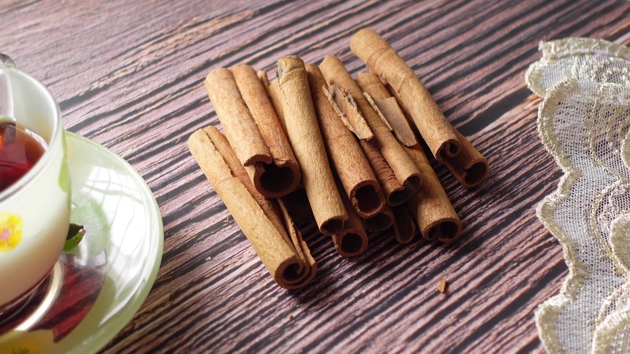 Kanelstenger og en kopp te på et trebord