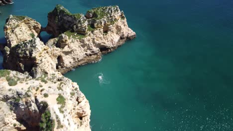 movimiento de órbita panorámica en una hermosa vista aérea de los acantilados en ponta da piedade, lagos, portugal