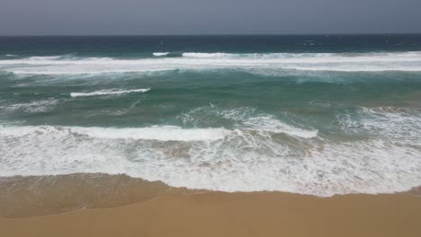 toma aérea de grandes olas rompiendo en la playa de cofete en fuerteventura, isla canaria