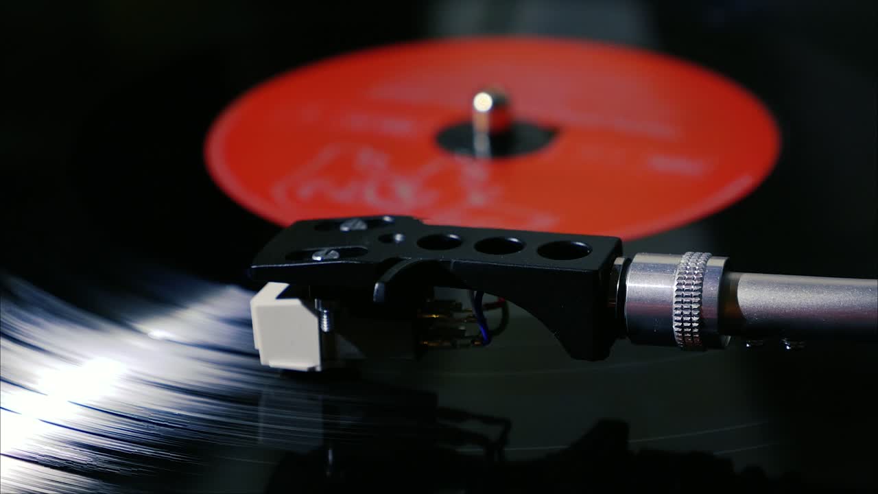 Panning shot of black vintage vinyl record spinning on a turntable slow motion
