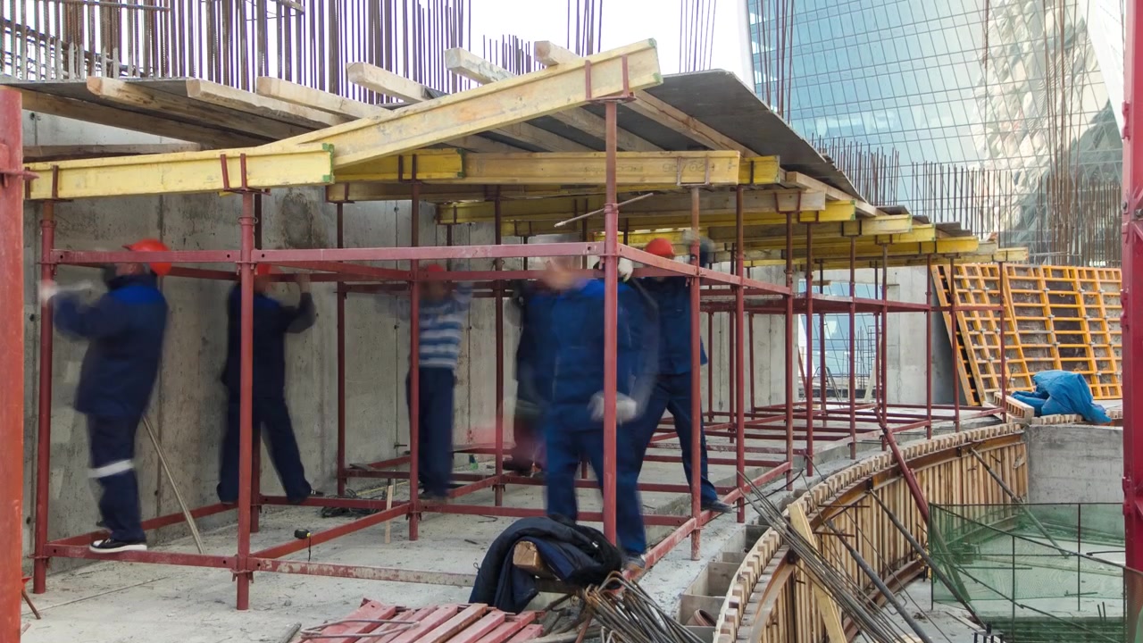 Ouvriers du bâtiment montant des barres d'acier utilisées pour renforcer le béton avec des échafaudages et des outils sur un immeuble de grande hauteur en timelapse, gratte-ciel. Bâtiment en construction