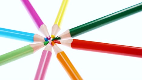 los lápices multicolores de los niños giran sobre un fondo blanco.