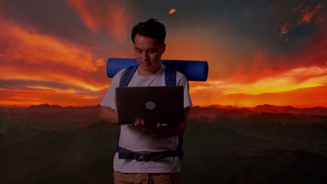 hombre trabajando en una computadora portátil en las montañas al atardecer