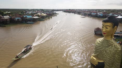 estatua gigante de buda con vistas a la aldea flotante inundada durante la temporada del monzón
