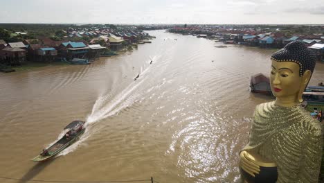 giant buddha statue overlooking flooded floating village during monsoon season