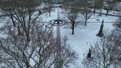 aerial tilt up of snow covered park in winter