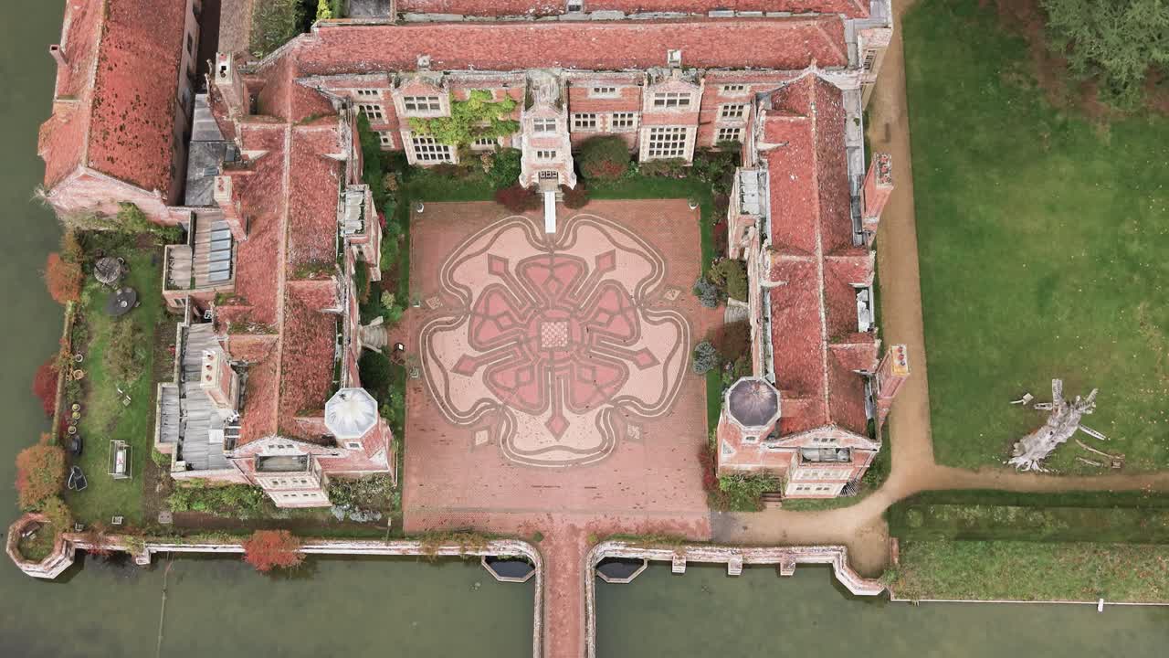 Kentwell Hall, Long Melford, Suffolk, United Kingdom - A Historic Manor Showcases a Detailed Patterned Courtyard Framed by Red-Brick Architecture and Surrounding Greenery - Aerial Drone Shot
