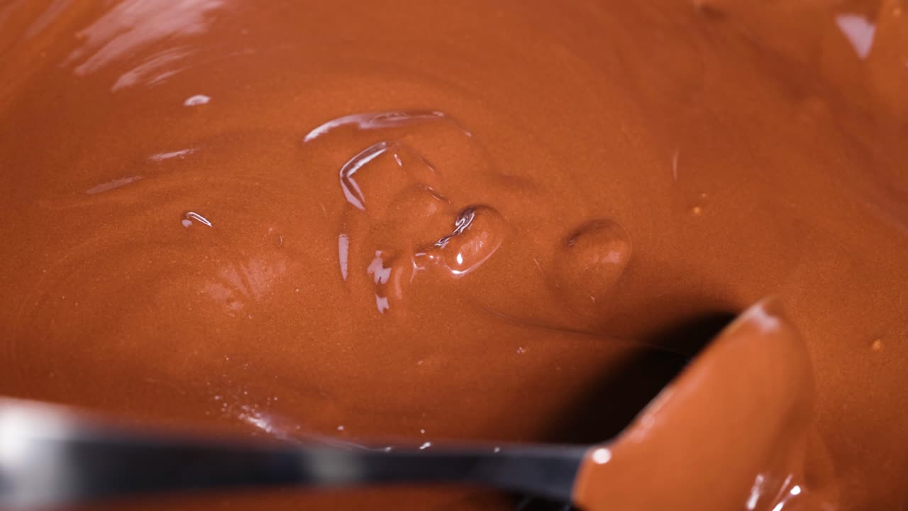 Smooth chocolate being stirred and poured