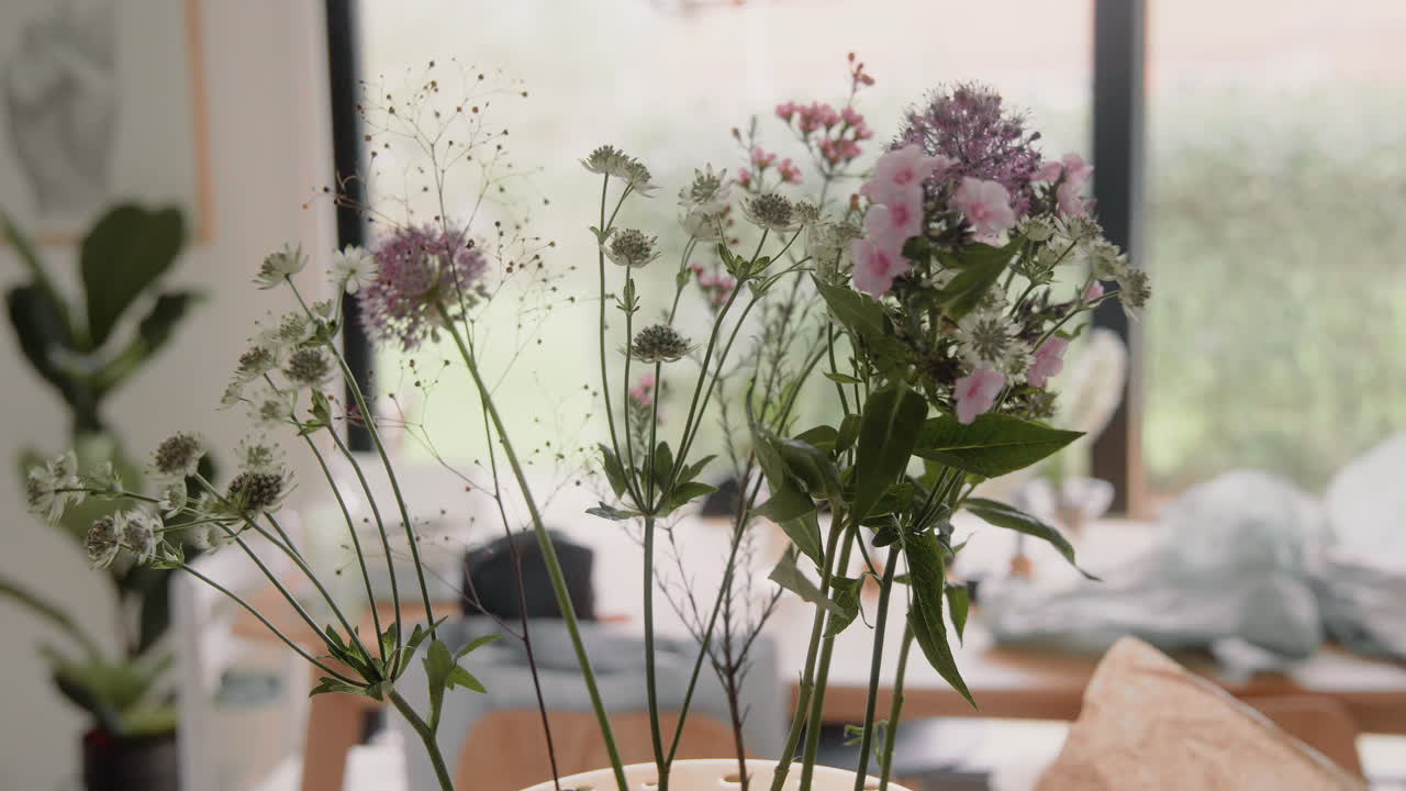 신선한 꽃으로 꽃병을 장식하는 젊은 여성, 집 안의 탁자에 있는 꽃다발, 손으로 4k 확대