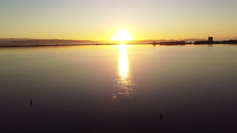 Sensacional-Vista-Aérea-Del-Amanecer-En-La-Laguna-De-Sant&#39;antioco,-Aguas-Tranquilas-Y-Claras