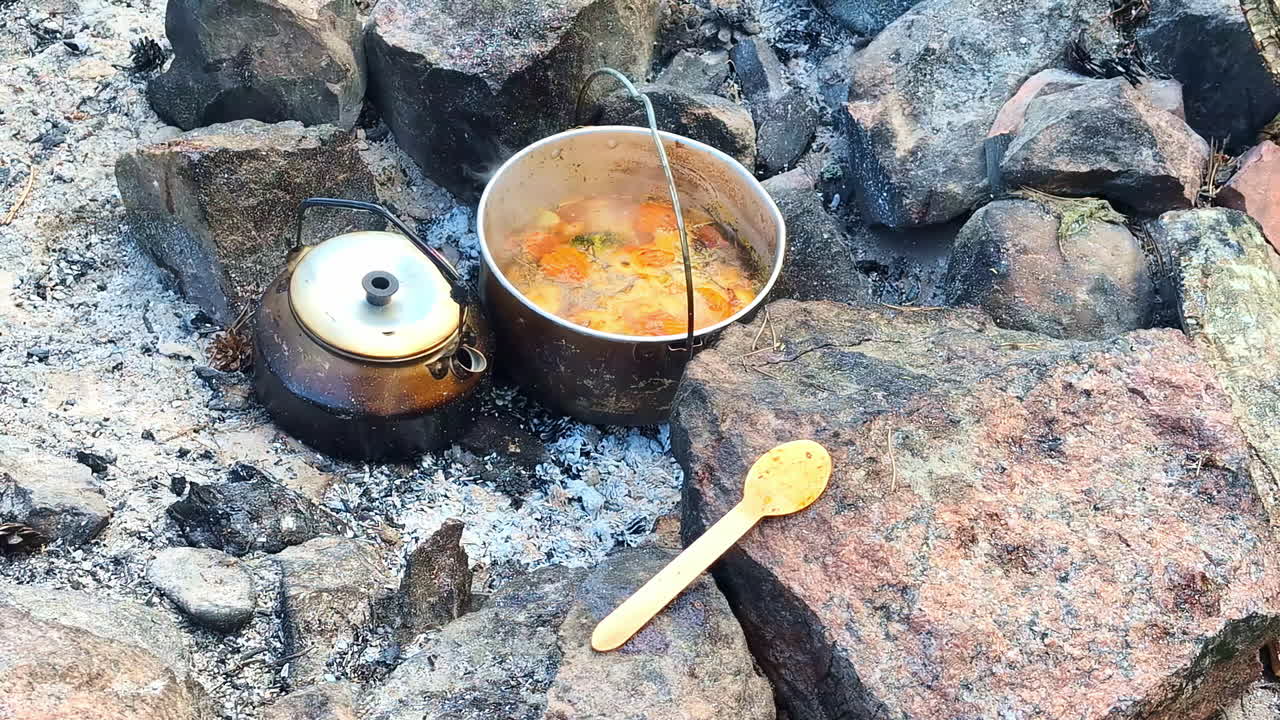 캠프 불 에 채소 수프 와 차 를 요리 하는 것