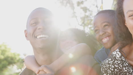 retrato al aire libre de una familia sonriente en el jardín en casa contra el sol abrasador