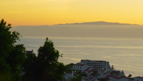 seeing la gomera island covered in fog, from tenerife during sunset