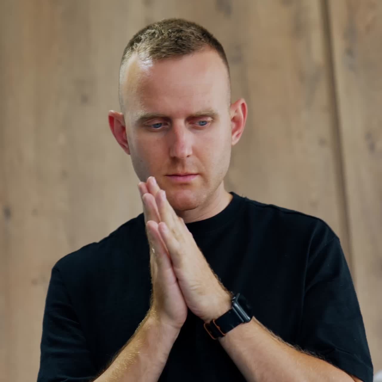 Anxious Caucasian man worrying for his wife delivering a baby. Husband holds hands near his face rubbing them nervously